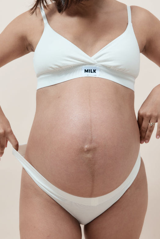 Pregnant woman wearing a white maternity underwear from Milk Label 
